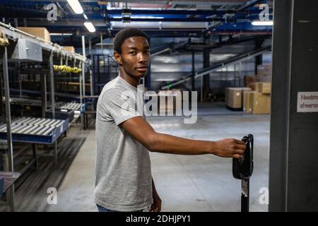 Lavoratore manuale con carrello elevatore a forche che lavora presso il centro di distribuzione di Samsonite a Oudenaarde, Belgio. Foto Stock