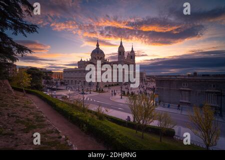 Maestosa vista della Cattedrale dell'Almudena sullo sfondo del tramonto arancione Cielo a Madrid Foto Stock