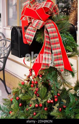 Mailbox decorata per Natale con un grande arco rosso di plaid e verde Foto Stock