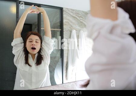 donna urla di fronte al mirro Foto Stock