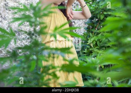 Ritratto della donna che guarda le sue piante di Marijuana Foto Stock