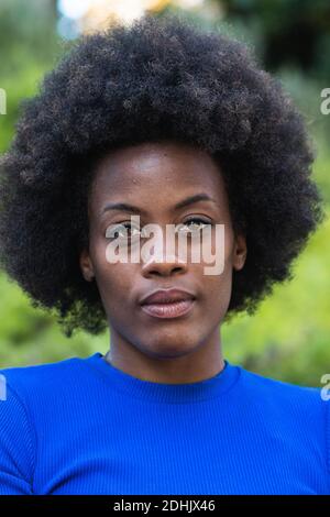 Donna nera con acconciatura Afro che guarda la fotocamera Foto Stock