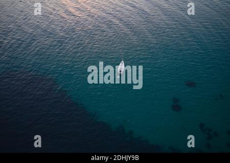 Da sopra drone vista di solitario yacht moderno galleggiare su superficie increspata di acque di mare calme Foto Stock
