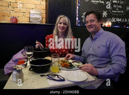 Noelle Gleeson (a sinistra) e Jonathan Maxwell gusteranno il loro pranzo al Mourne Seafood Bar nel centro di Belfast, mentre le aziende in tutta l'Irlanda del Nord riaprono le loro porte a seguito di un blocco di due settimane di interruzione del circuito volto a arginare la diffusione del coronavirus. Foto Stock