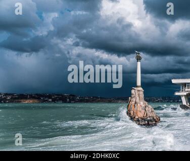 Monumento alle navi allagate sul terrapieno della città sullo sfondo della grande onda in mare tempestoso e nuvole piovose al tramonto. Sevastopol, Crimea Foto Stock