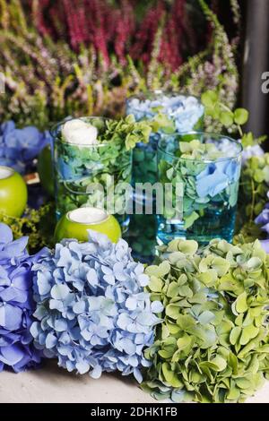 Decorazione domestica autunnale con i fiori di hortensia (hydrangea) e i portacandele di mela. Foto Stock