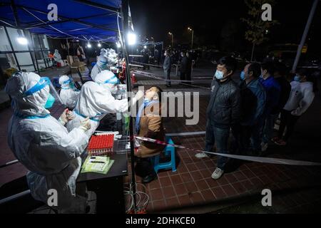 (201212) -- CHENGDU, 12 dicembre 2020 (Xinhua) -- i cittadini ricevono test sugli acidi nucleici al Chengdu Modern Industrial Park nel distretto di Pidu di Chengdu, provincia sudoccidentale del Sichuan, 11 dicembre 2020. Il Chengdu del sud-ovest della Cina ha lanciato un test drive di acido nucleico venerdì, offrendo test gratuiti a tutti i residenti nel distretto di Pidu della città, dove diversi nuovi casi COVID-19 sono emersi dall'inizio di questa settimana. Il quartier generale di prevenzione e controllo COVID-19 del distretto ha detto che l'unità è iniziata alle 18:00, con le spese di test coperte dal governo distrettuale. (Xinhua/Shen Bohan) Foto Stock