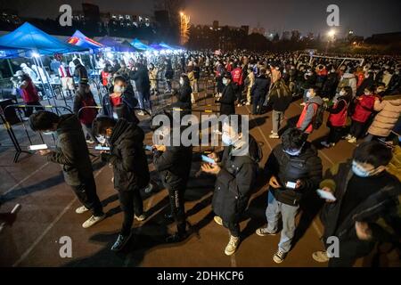 (201212) -- CHENGDU, 12 dicembre 2020 (Xinhua) -- gli studenti aspettano in fila per i test sugli acidi nucleici presso l'Università Xihua nel distretto di Pidu di Chengdu, provincia sudoccidentale del Sichuan, 11 dicembre 2020. Il Chengdu del sud-ovest della Cina ha lanciato un test drive di acido nucleico venerdì, offrendo test gratuiti a tutti i residenti nel distretto di Pidu della città, dove diversi nuovi casi COVID-19 sono emersi dall'inizio di questa settimana. Il quartier generale di prevenzione e controllo COVID-19 del distretto ha detto che l'unità è iniziata alle 18:00, con le spese di test coperte dal governo distrettuale. (Xinhua/Shen Bohan) Foto Stock