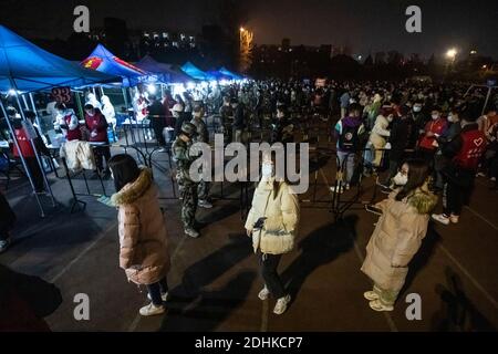 (201212) -- CHENGDU, 12 dicembre 2020 (Xinhua) -- gli studenti aspettano in fila per i test sugli acidi nucleici presso l'Università Xihua nel distretto di Pidu di Chengdu, provincia sudoccidentale del Sichuan, 11 dicembre 2020. Il Chengdu del sud-ovest della Cina ha lanciato un test drive di acido nucleico venerdì, offrendo test gratuiti a tutti i residenti nel distretto di Pidu della città, dove diversi nuovi casi COVID-19 sono emersi dall'inizio di questa settimana. Il quartier generale di prevenzione e controllo COVID-19 del distretto ha detto che l'unità è iniziata alle 18:00, con le spese di test coperte dal governo distrettuale. (Xinhua/Shen Bohan) Foto Stock