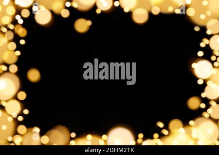 Cornice gialla con luci natalizie per l'uso in sovrapposizione. Macchie tonde gialle su sfondo nero forma di una fama. Foto Stock