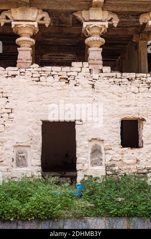 Hampi, Karnataka, India - 4 novembre 2013: Via Hampi Bazar. Storico edificio vuoto e rovinoso con tetto decorato che tiene colonne e affreschi su cui Foto Stock