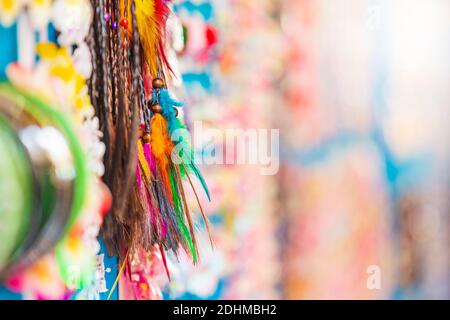 Piccoli souvenir colorati appesi su una parete del display in un mercato di una attrazione turistica, il lago di Garda, Italia. Foto Stock