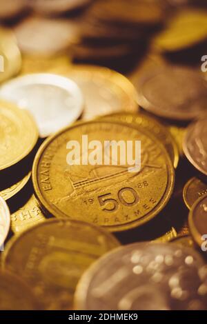 Pila di monete d'oro diverse sul tavolo. Moneta greca Drachma Foto Stock