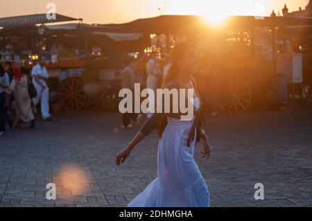 Marrakech, Marocco. 08-10/2018. Jemaa El Fna è la piazza principale e il mercato nel quartiere medina di Marrakech (città vecchia). Bella donna che cammina al tramonto. Foto Stock