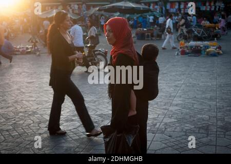 Marrakech, Marocco. 08-10/2018. Jemaa El Fna è la piazza principale e il mercato nel quartiere medina di Marrakech (città vecchia). Madre che pregava per strada con chi Foto Stock