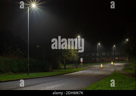 Immagine notturna della strada suburbana con rotonda e strada luci Foto Stock