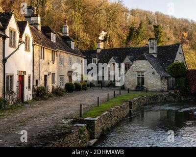 Il fumo sorge dai camini dei cottage tradizionali su Water Lane nel pittoresco villaggio di Castle Combe, in Inghilterra Cotswolds. Foto Stock