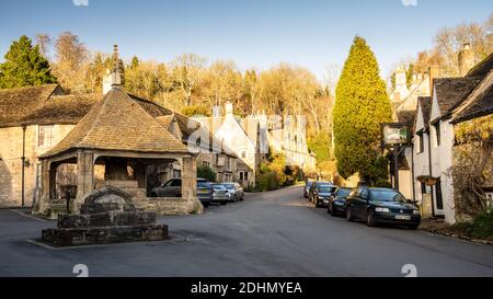 Il mercato medievale croce e cottage tradizionali si trovano sulla strada nel pittoresco villaggio di Castello Combe. Foto Stock