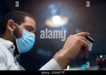 Uomo africano nero che tiene le mani carta di credito e telefono cellulare, il pagamento online durante la corona pandemic.Technology, internet banking, e-commerce healtcare Foto Stock