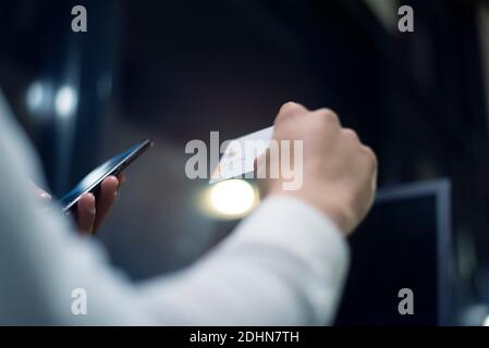 Uomo africano nero che tiene le mani carta di credito e telefono cellulare, il pagamento online durante la corona pandemic.Technology, internet banking, e-commerce healtcare Foto Stock