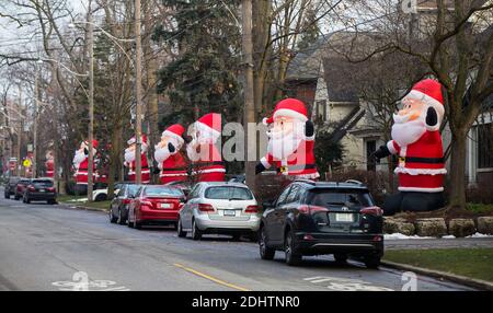 Toronto, Canada. 11 Dicembre 2020. Le clausole di Santa gonfiabili di dimensioni giganti sono viste su Inglewood Drive a Toronto, Canada, 11 dicembre 2020. A partire dal 2013, decine di clausole di Santa gonfiabili alte 14 piedi si estendono lungo Inglewood Drive a Toronto durante la stagione delle vacanze, attirando molti visitatori. Credit: Zou Zheng/Xinhua/Alamy Live News Foto Stock