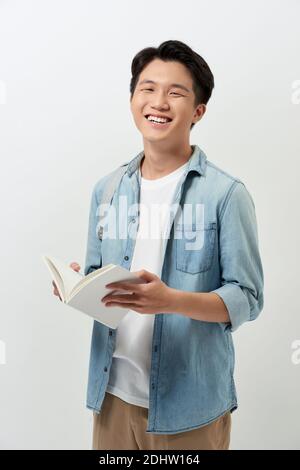 Studente sorridente in abiti casual con zaino isolato su sfondo bianco ritratto studio. Istruzione nel college universitario di scuola superiore co Foto Stock