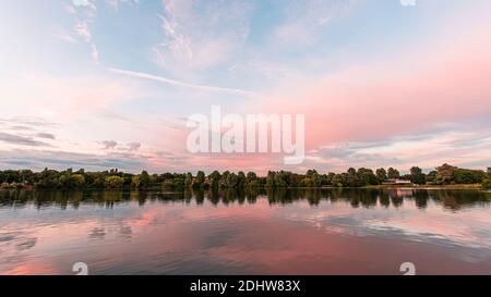 Tramonto sul lago Westport a Stoke on Trent, Staffordshire, UK.riflessione di cielo blu e nuvole rosa nella calma acqua surface.Bright paesaggio. Foto Stock