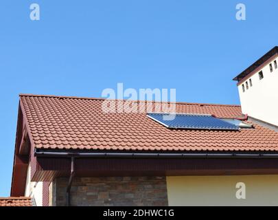 Primo piano del sistema di riscaldamento ad acqua solare sottovuoto, gocciolatoio sul tetto della casa in piastrelle rosse. Soal Energy for Energy Efficiency Modern House Building Concept. Foto Stock