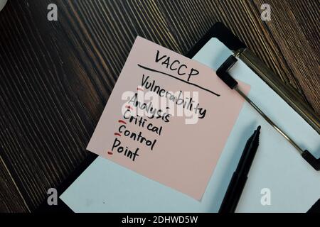 VACCP - Vulnerability Analysis Critical Control Point scrive su note adesive isolate su tavola di legno. Foto Stock