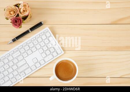 Uno spazio di lavoro minimo con mouse e tastiera per computer wireless bianchi con caffè in una tazza di ceramica bianca. Foto Stock