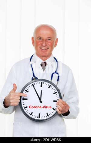 Ein Arzt Haelt eine Uhr. Auf dem Ziffernblatt ist es 5 Minuten vor 12, Coronavirus, MR: Si Foto Stock