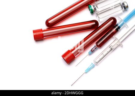 fiale per uso medico, provette per analisi con campioni di sangue e siringa su sfondo chiaro Foto Stock