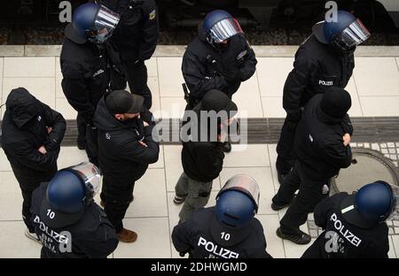 Dresda, Germania. 12 dicembre 2020. Gli ufficiali di polizia portano gli uomini che arrivano alla stazione principale per la dimostrazione per verificare la loro identità. La polizia di Dresda si prepara a protestare contro la politica di Corona. L'iniziativa "Lateral Thinking" aveva registrato un raduno per 4000 persone, che da allora è stato vietato dalla corte. Credit: Robert Michael/dpa-Zentralbild/dpa/Alamy Live News Foto Stock