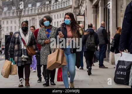 Londra, Regno Unito. 12 dicembre 2020. Gli acquirenti di Regent Street trasportano borse per la spesa con l'aumento del numero di casi di coronavirus nella capitale. I rivenditori sperano che le vendite fisiche prenderanno nella corsa fino a Natale. Ciò avviene sullo sfondo di due grandi rivenditori, Debenhams e Arcadia, proprietario di Topshop, che si sono abbattute nell'amministrazione nelle ultime settimane. Credit: Stephen Chung / Alamy Live News Foto Stock