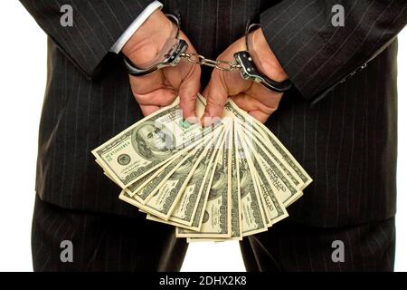Manager mit Dollar Geldscheinen in der Hand, Hanschellen, verhaftet, Schwarzgeld,