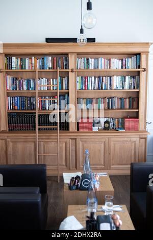 Luxury classic interno della libreria di casa. Salotto con libreria, libri,  poltrona, divano letto e camino.