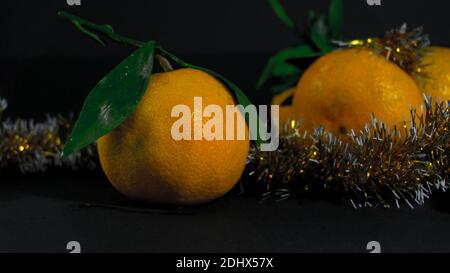 Taglio tangerino con una foglia verde su sfondo nero Foto Stock
