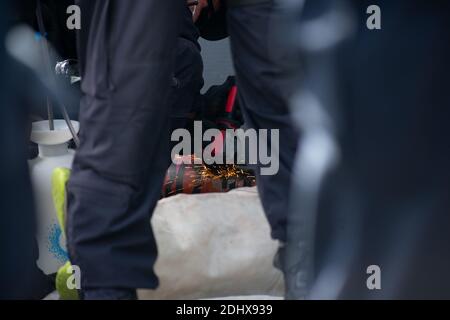 Melbourne, Victoria. 12 dicembre 2020. Extinction Rebellion Rally. La polizia tenta di rimuovere la serratura metallica spessa dalle braccia dei manifestanti prima di arrestarli. Credit: Jay Kogler/Alamy Live News Foto Stock