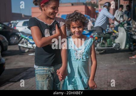 Marrakech, Marocco. 08-10/2018. Jemaa El Fna è la piazza principale e il mercato nel quartiere medina di Marrakech (città vecchia). Sorelline sorridenti mentre le mani sono tenute. Foto Stock