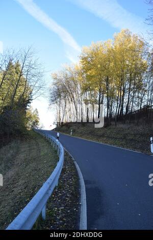 Strada curvilinea attraverso l'area sportiva invernale Hohe Acht durante fine autunno Foto Stock