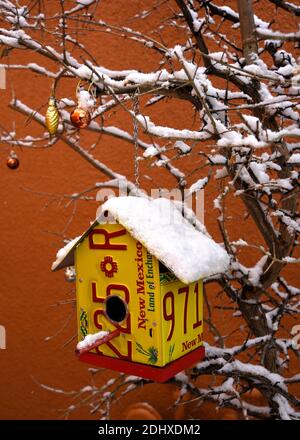 Le case degli uccelli realizzate con targhe di automobili riciclate sono appese in un piccolo albero a Santa Fe, New Mexico. Foto Stock