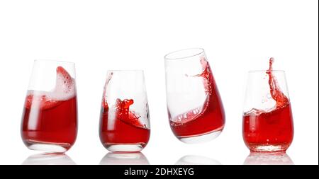 Set di bicchieri con spruzzi di succo rosso su un bianco sfondo Foto Stock