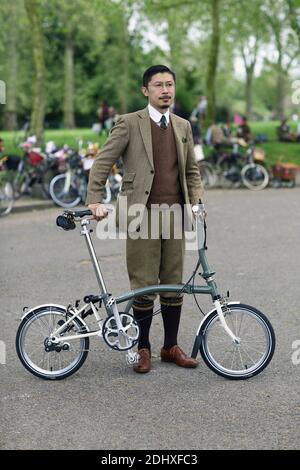 Un giovane vestito in tuta in piedi accanto alla bicicletta al Tweed Run di Londra, Regno Unito Foto Stock