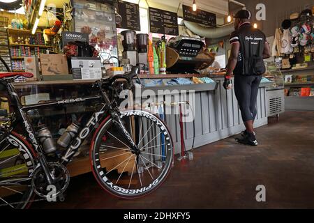 un uomo che gusta una tazza di caffè in un caffè all'interno la città mentre la sua bici si trova accanto a lui Ciclismo caffè Look mamma No Hands a Londra, Regno Unito Foto Stock