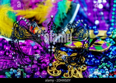 Mardi Gras elegante maschera in pizzo di metallo nero contro colori luminosi Perle e piume - sfondo bello Foto Stock