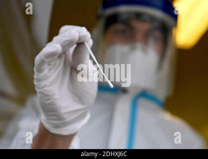 Berlino, Germania. 11 Dicembre 2020. Jonathan Premke, assistente medico, esegue un tampone alla gola per un test dell'antigene SARS-COV-2, presso il Corona Antigen Rapid Test Center di Mauerpark, nel quartiere berlinese di Prenzlauer Berg. Con questo metodo, è disponibile un risultato del test dopo 15-30 minuti. Credit: Pedersen/dpa-Zentralbild/ZB/dpa/Alamy Live News Foto Stock