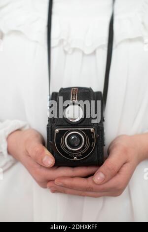 Vecchia fotocamera analogica degli anni '50 nelle mani di una ragazza Foto Stock