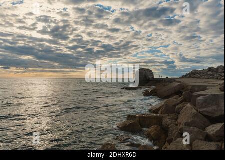 Roccia pulpita sull'Isola di Portland sulla costa del Dorset al tramonto con persone che arrampicano sulla roccia marina. Gran Bretagna. Foto Stock