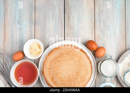 Pancake e ingredienti per cucinare su uno sfondo di legno chiaro. Foto Stock