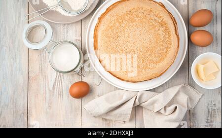 Uova, zucchero, farina, miele e pancake pronti con spazio da copiare su uno sfondo chiaro. Foto Stock